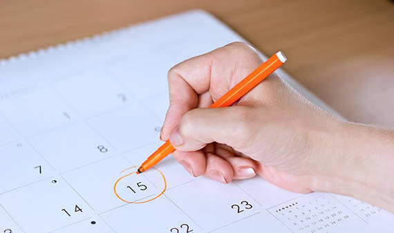 person circling date on calendar