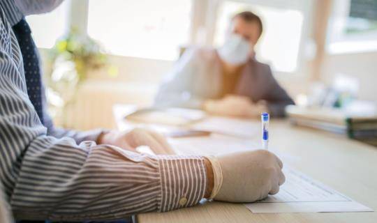 In-person real estate signing with people wearing masks