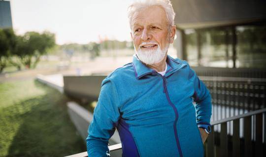 Elderly man smiles outside