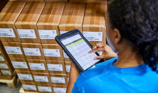 Worker at distribution center checks boxes