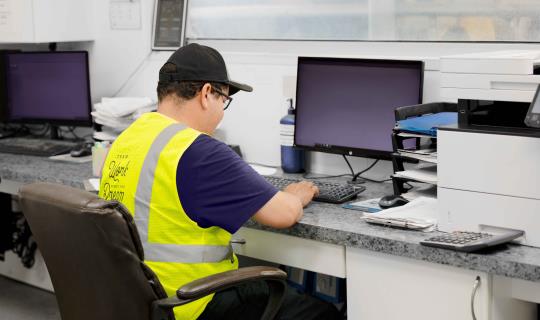 Dairy worker sitting at computer