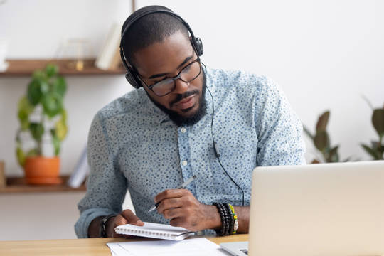 Man with laptop participating in an online class