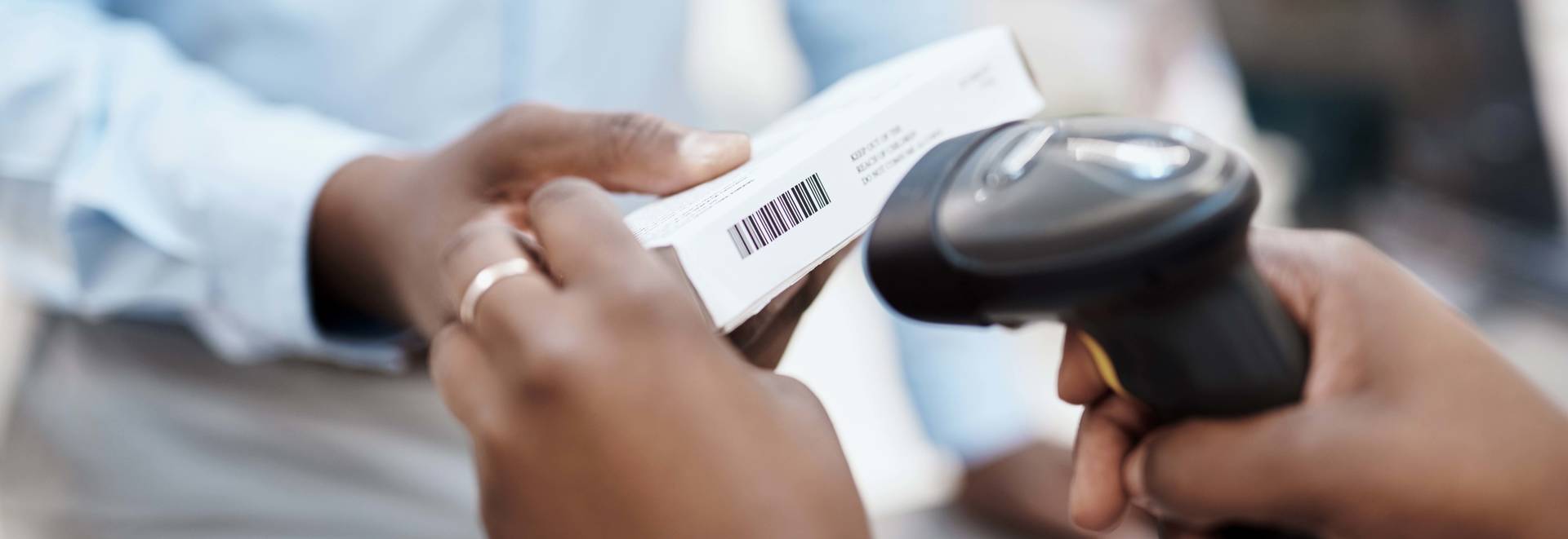 Closeup shot of a pharmacist scanning a box of medication for a customer