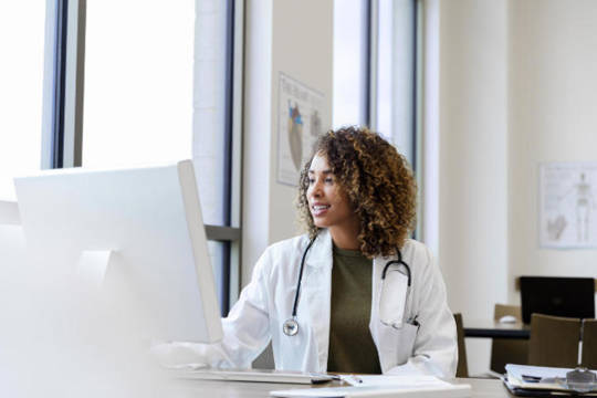 Female veterinarian looking at her computer screen in her office